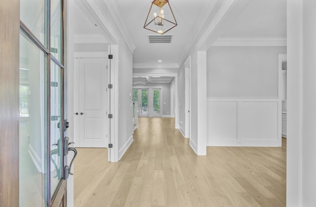1098 Reserve Ln, Awendaw, SC 29429 - foyer entrance with a chandelier, french doors, light wood finished floors, ornamental molding, and a wainscoted wall