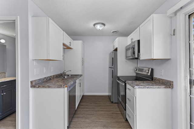 107 Hickory Ln Unit C, Ladson, SC 29456 - kitchen featuring stainless steel appliances, white cabinetry, a textured ceiling, and wood finished floors