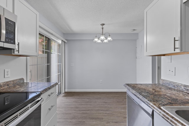 107 Hickory Ln Unit C, Ladson, SC 29456 - kitchen with appliances with stainless steel finishes, a textured ceiling, a chandelier, dark wood-style flooring, and white cabinetry