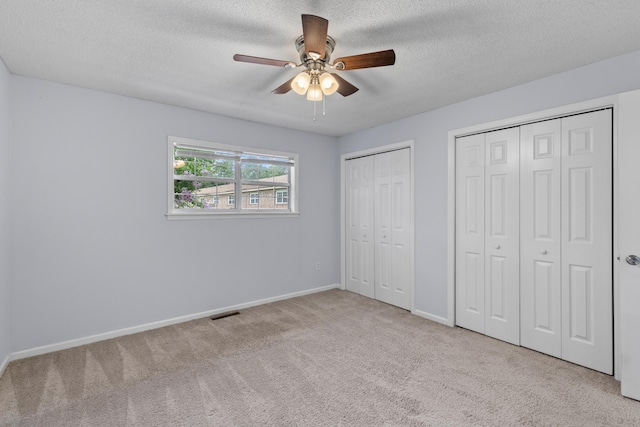 107 Hickory Ln Unit C, Ladson, SC 29456 - unfurnished bedroom featuring carpet, multiple closets, a textured ceiling, and ceiling fan