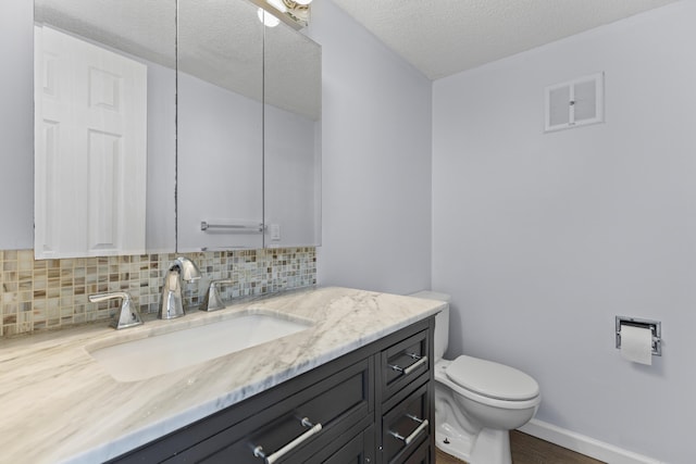 107 Hickory Ln Unit C, Ladson, SC 29456 - bathroom with decorative backsplash, vanity, a textured ceiling, and wood finished floors