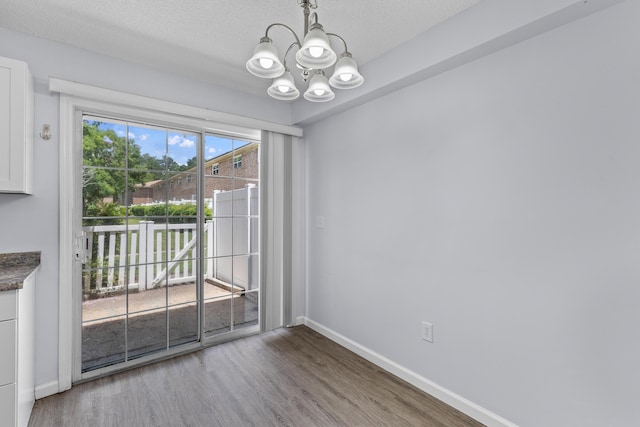 107 Hickory Ln Unit C, Ladson, SC 29456 - unfurnished dining area with a chandelier, wood finished floors, and a textured ceiling