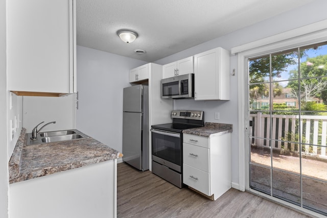107 Hickory Ln Unit C, Ladson, SC 29456 - kitchen featuring stainless steel appliances, light wood-type flooring, white cabinets, and a textured ceiling