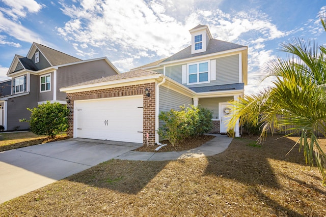 view of front of house with a garage, driveway, and brick siding