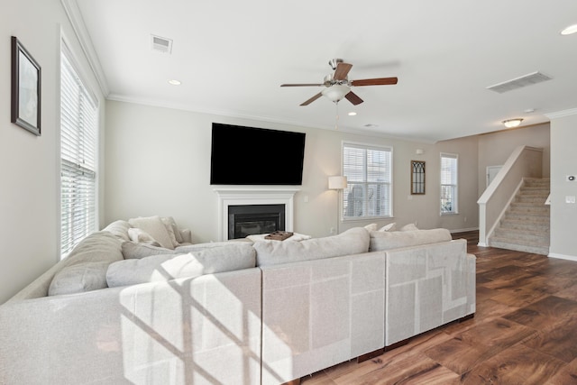 living room featuring visible vents, crown molding, and stairs