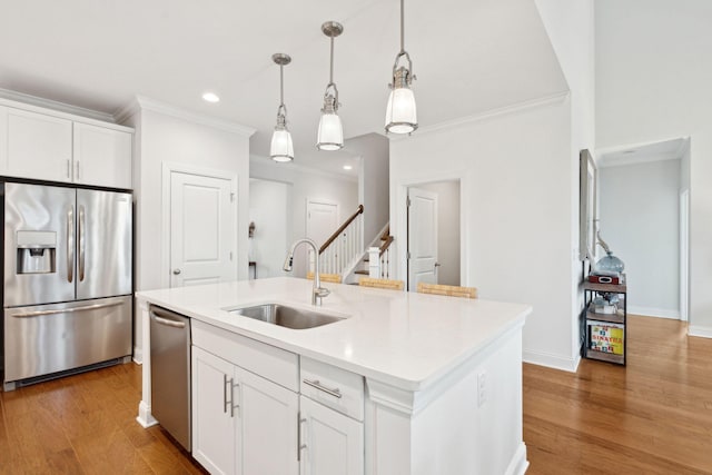 kitchen featuring a kitchen island with sink, appliances with stainless steel finishes, sink, and white cabinets