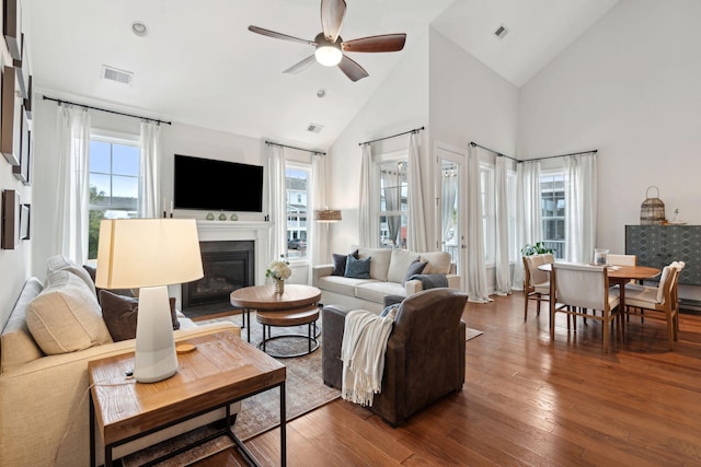 living room featuring hardwood / wood-style flooring, ceiling fan, and high vaulted ceiling