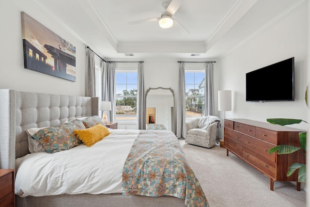 carpeted bedroom featuring a raised ceiling, ornamental molding, and ceiling fan