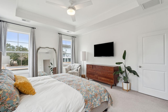 carpeted bedroom with crown molding, ceiling fan, and a tray ceiling