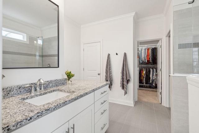 bathroom with crown molding, tiled shower, vanity, and tile patterned floors