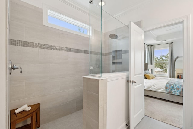 bathroom with ornamental molding, tile patterned floors, and a tile shower