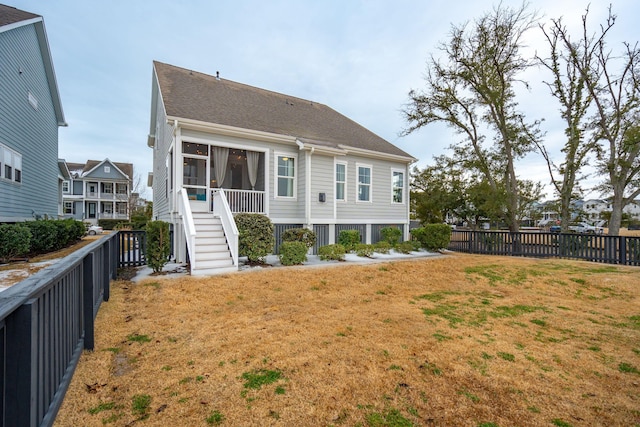 rear view of property with a lawn