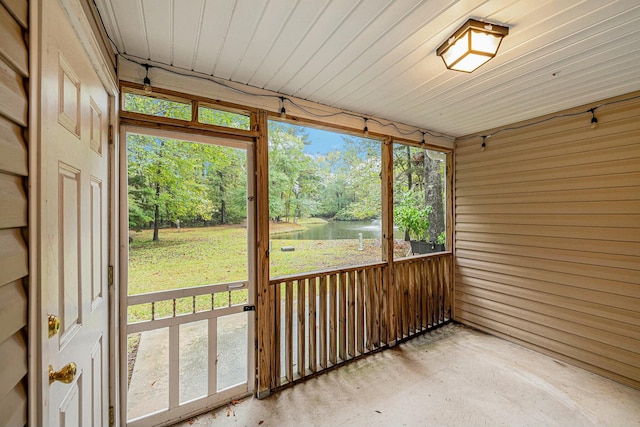 unfurnished sunroom featuring a water view