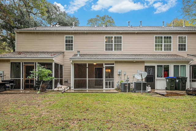 back of property with a sunroom, cooling unit, and a lawn