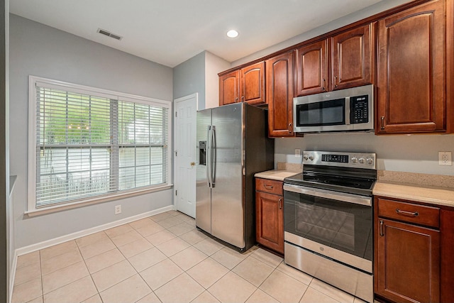 kitchen featuring stainless steel appliances and light tile patterned flooring