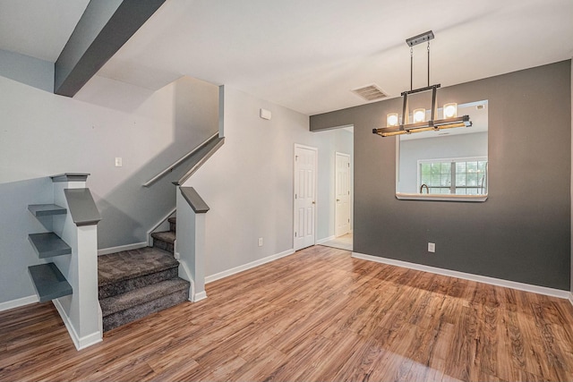 interior space featuring wood-type flooring and a chandelier