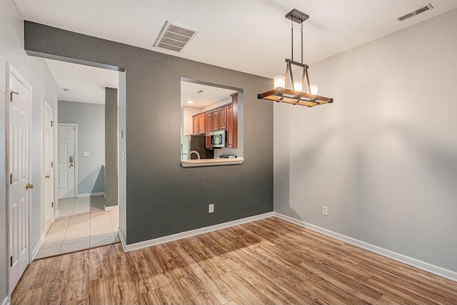 unfurnished dining area with light hardwood / wood-style flooring