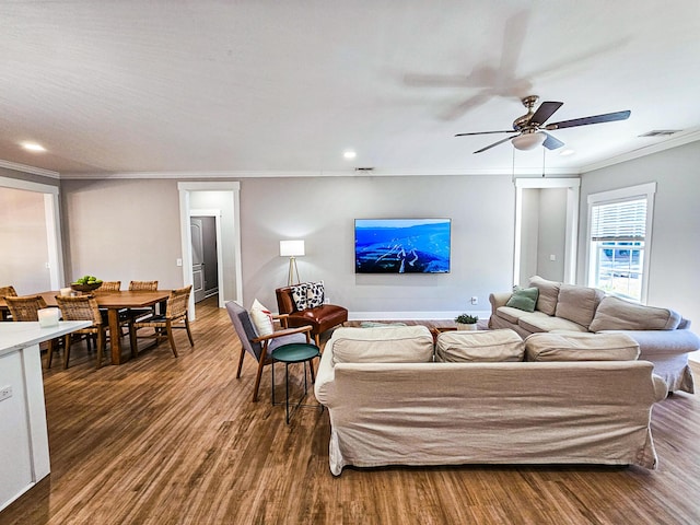 living room with dark wood-type flooring, ceiling fan, and ornamental molding