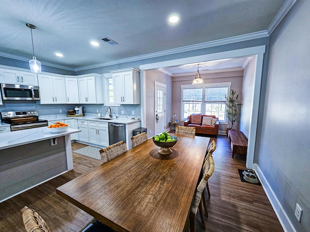 dining space with dark hardwood / wood-style flooring, sink, and crown molding