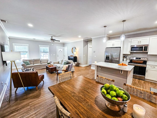 dining space featuring ceiling fan, ornamental molding, and hardwood / wood-style floors