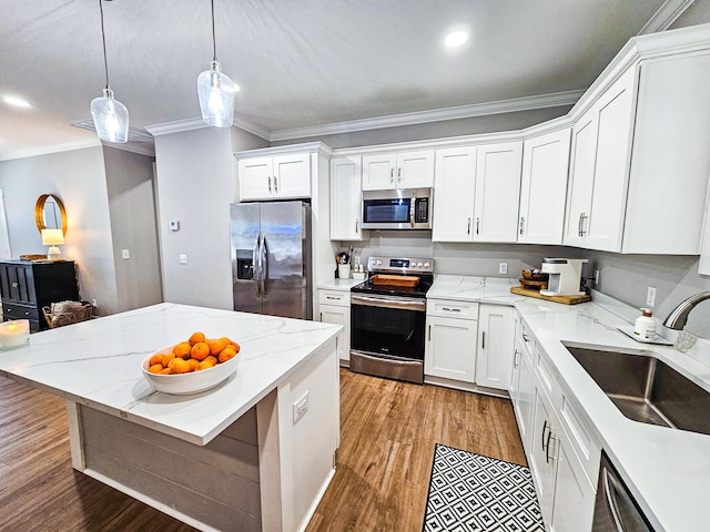 kitchen with decorative light fixtures, sink, white cabinetry, and stainless steel appliances