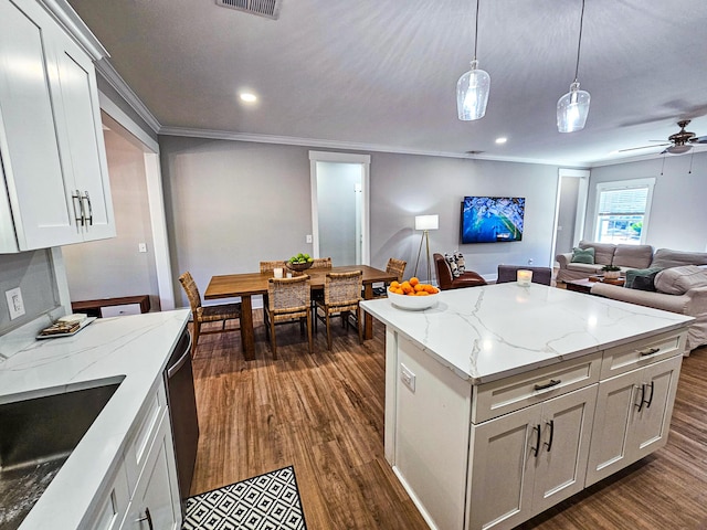 kitchen featuring white cabinets, hanging light fixtures, and light stone countertops