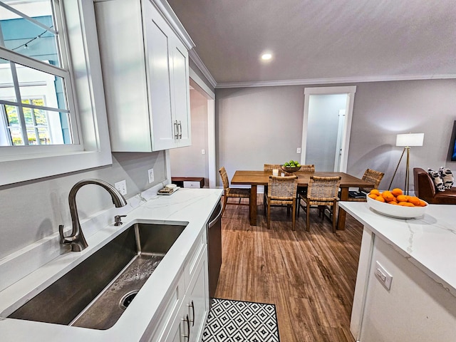 kitchen with white cabinetry, dark hardwood / wood-style floors, light stone countertops, crown molding, and sink