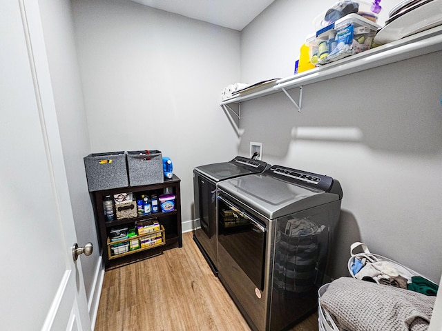 laundry area with light hardwood / wood-style floors and washer and clothes dryer