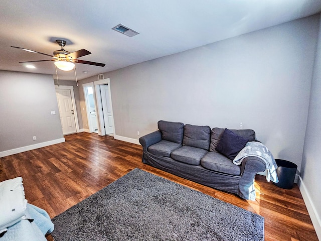 living room featuring ceiling fan and dark hardwood / wood-style flooring