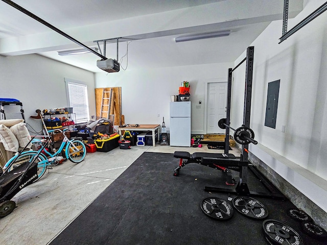 garage with a garage door opener, white refrigerator, and electric panel