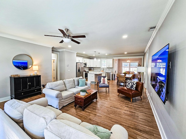 living room featuring ceiling fan, ornamental molding, and hardwood / wood-style floors