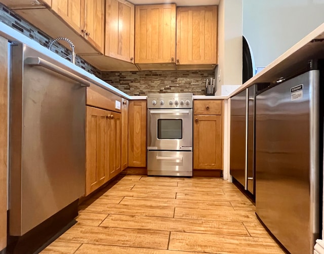 kitchen featuring light hardwood / wood-style flooring, backsplash, and premium appliances