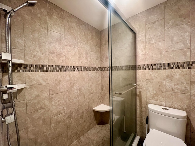 bathroom featuring tile walls, toilet, and an enclosed shower