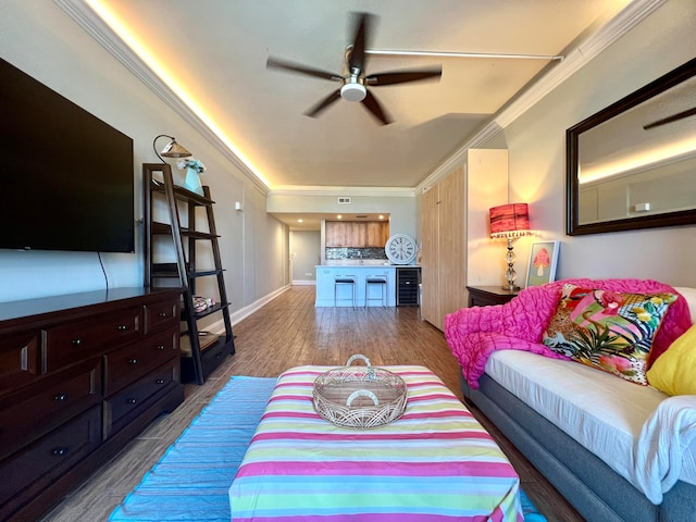 living room with wood-type flooring, crown molding, and ceiling fan