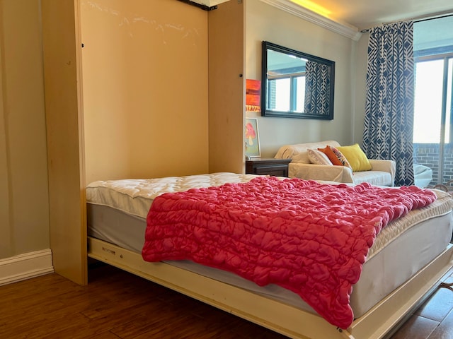 bedroom with dark wood-type flooring, multiple windows, and crown molding