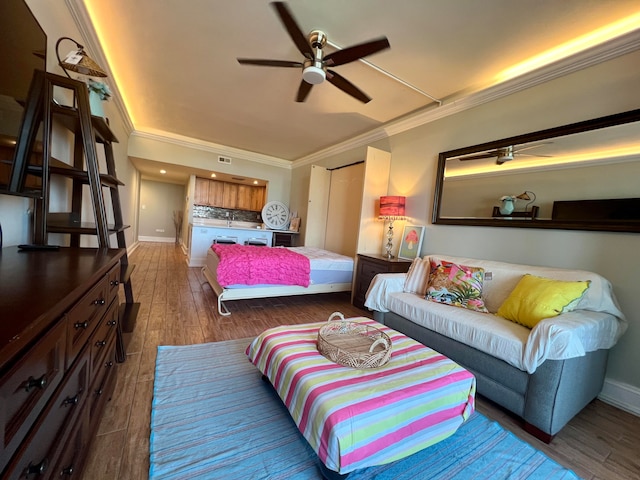 bedroom with dark wood-type flooring, ceiling fan, and ornamental molding