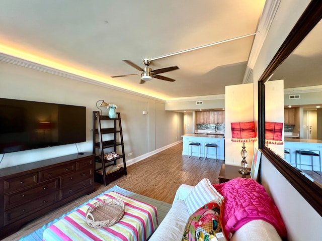 living room featuring ornamental molding, wood-type flooring, and ceiling fan