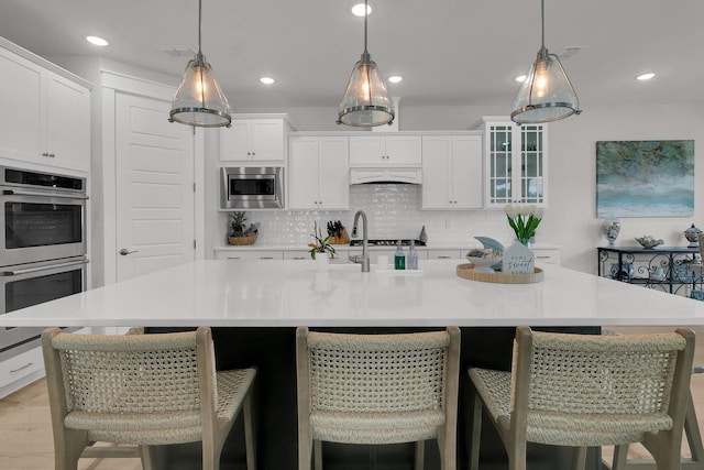 kitchen featuring white cabinets, stainless steel appliances, and a large island