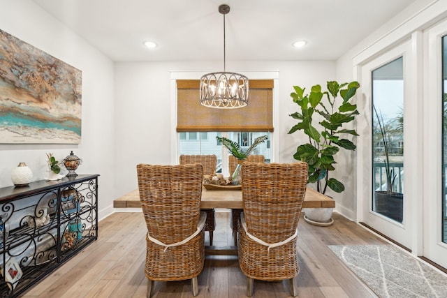 dining space with hardwood / wood-style flooring and an inviting chandelier