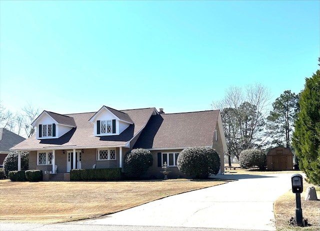 new england style home with a porch and a front yard