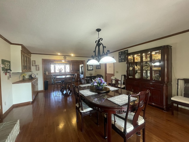 dining area featuring baseboards, a textured ceiling, ornamental molding, and dark wood-type flooring