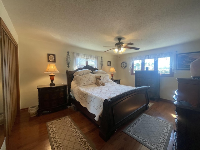 bedroom featuring a ceiling fan, a textured ceiling, baseboards, and wood finished floors