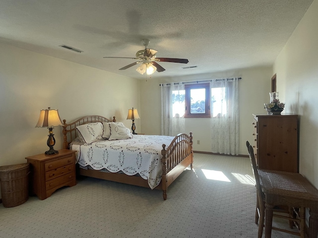 bedroom featuring a textured ceiling, ceiling fan, and visible vents