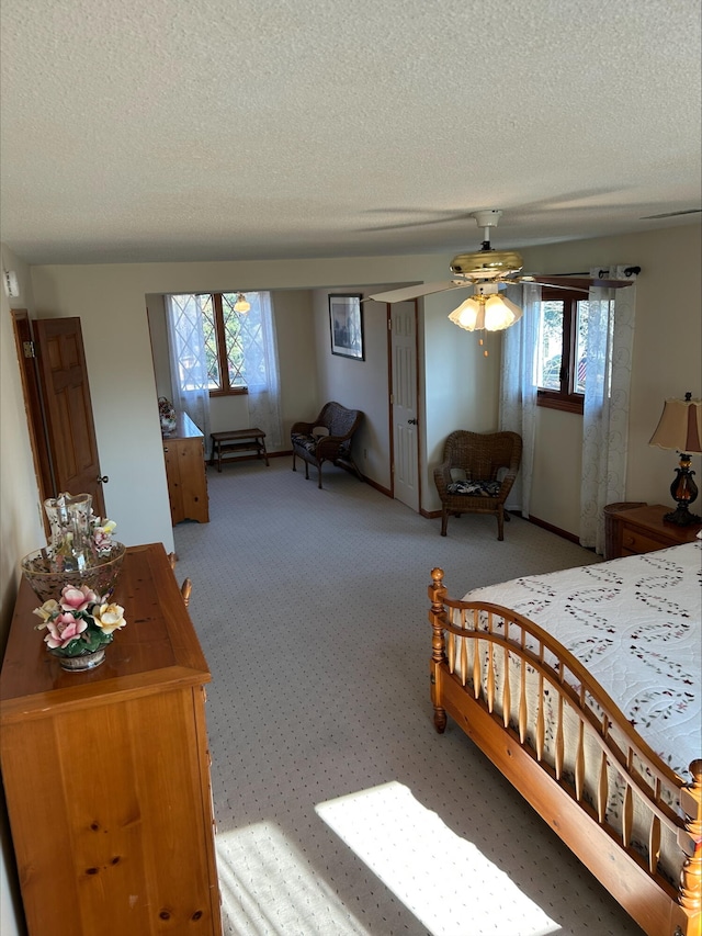 bedroom with a textured ceiling and light colored carpet