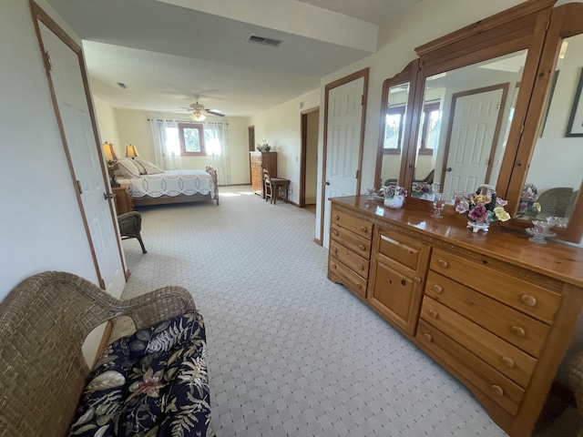 bedroom featuring light colored carpet, visible vents, and ceiling fan