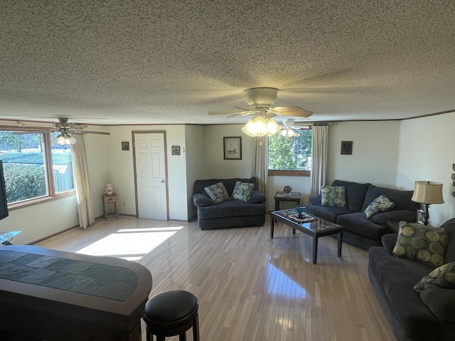 living room with plenty of natural light, light wood-style flooring, and a textured ceiling