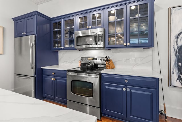 4 Beaufain St Unit 207, Charleston, SC 29401 - kitchen featuring appliances with stainless steel finishes, blue cabinets, glass insert cabinets, and dark wood-style floors
