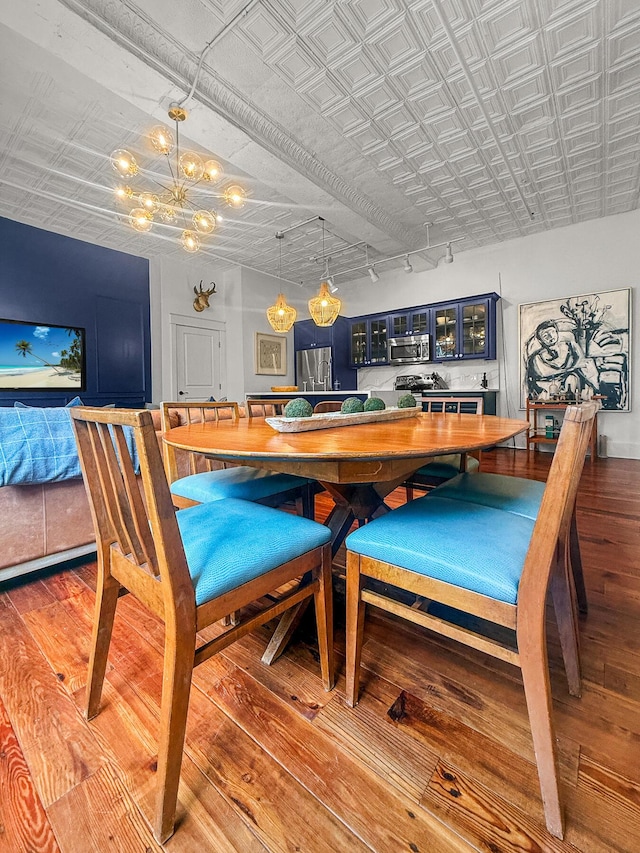 4 Beaufain St Unit 207, Charleston, SC 29401 - dining room featuring light wood-type flooring, a chandelier, rail lighting, and an ornate ceiling