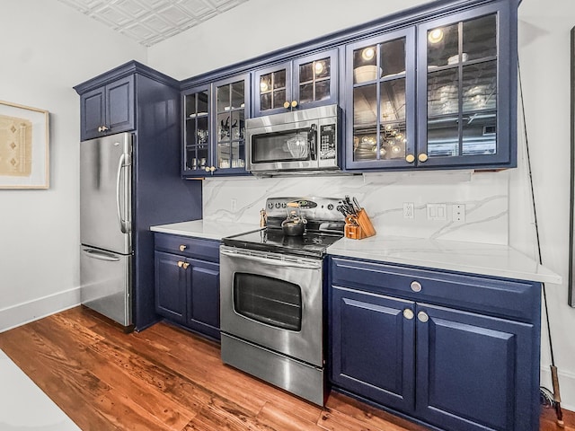 4 Beaufain St Unit 207, Charleston, SC 29401 - kitchen with appliances with stainless steel finishes, blue cabinetry, an ornate ceiling, dark wood-type flooring, and light countertops