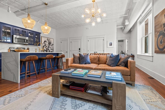 4 Beaufain St Unit 207, Charleston, SC 29401 - living room featuring wood finished floors, a chandelier, and a towering ceiling